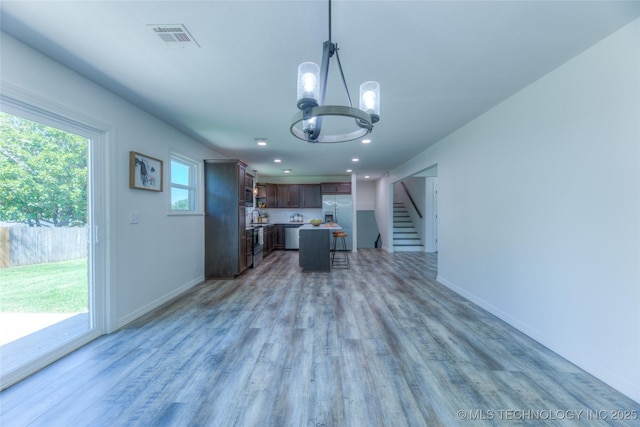 kitchen with visible vents, light countertops, light wood-type flooring, a chandelier, and stainless steel refrigerator with ice dispenser