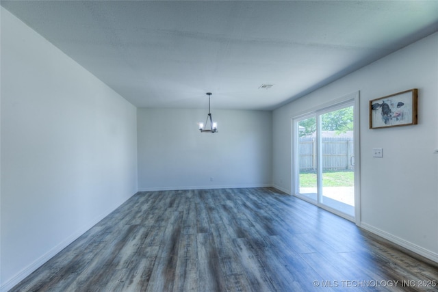 unfurnished room featuring a chandelier, dark wood-style flooring, visible vents, and baseboards