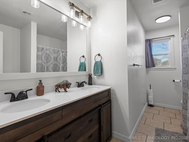 full bath featuring double vanity, a sink, visible vents, and tile patterned floors