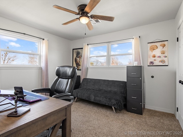 office area with a ceiling fan, light carpet, visible vents, and baseboards