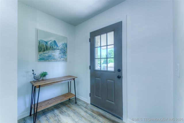 doorway to outside with wood finished floors and baseboards