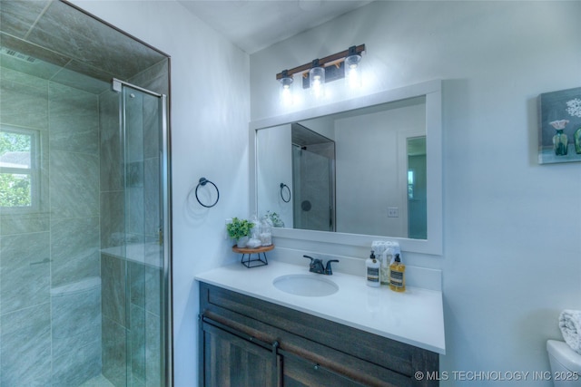 full bath featuring visible vents, toilet, vanity, and a stall shower