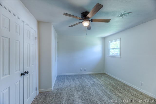 unfurnished bedroom featuring baseboards, carpet flooring, visible vents, and a closet