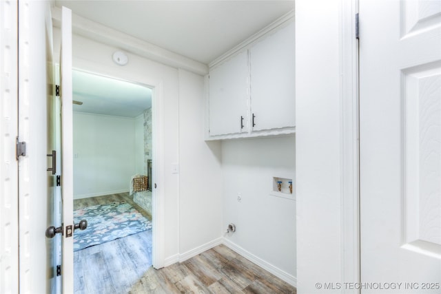 laundry area with hookup for an electric dryer, baseboards, light wood-style floors, washer hookup, and cabinet space