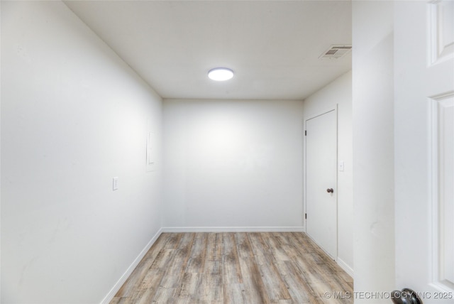 unfurnished room featuring baseboards, visible vents, and light wood finished floors