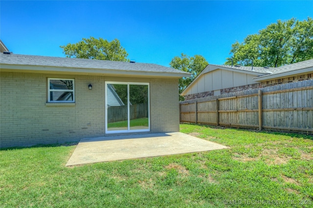 back of house with brick siding, a patio area, a lawn, and fence