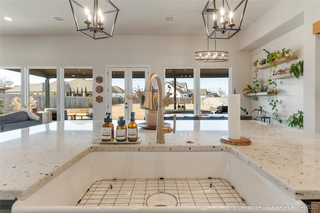 kitchen with a wealth of natural light, visible vents, a sink, and french doors