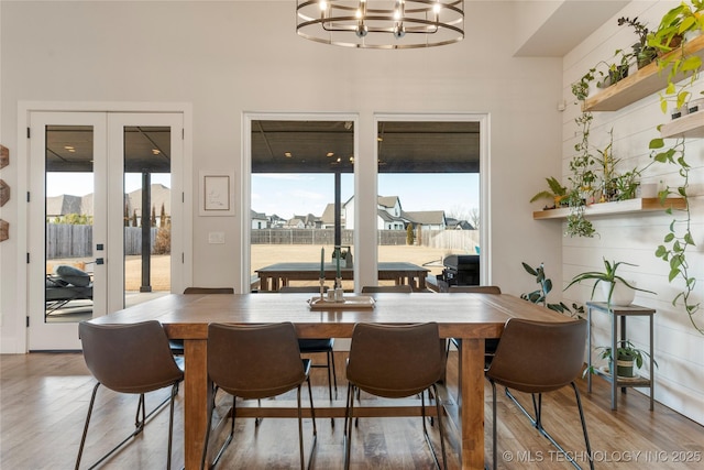 dining space featuring a chandelier, french doors, and wood finished floors