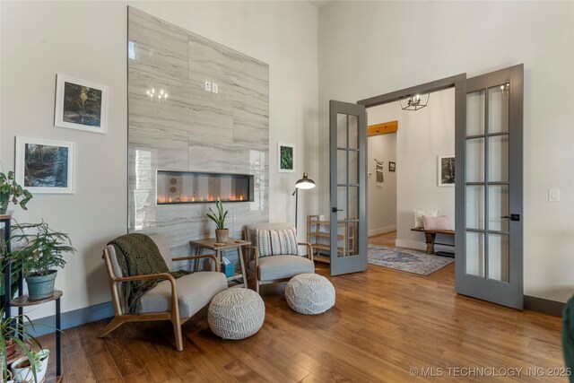 2715 E 136th St S, Bixby, OK 74008 - sitting room with french doors, wood finished floors, a towering ceiling, and a fireplace