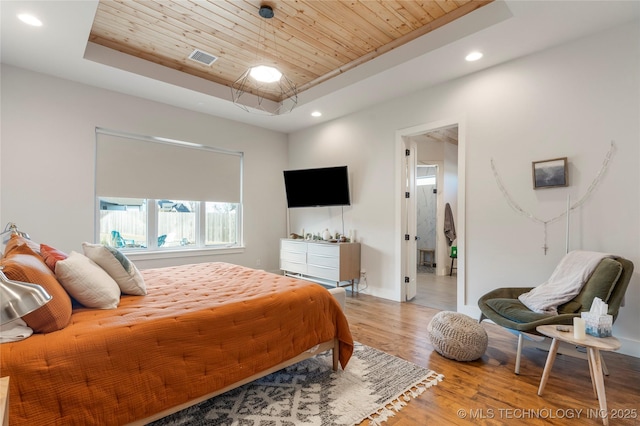 bedroom with a tray ceiling, wooden ceiling, wood finished floors, and recessed lighting