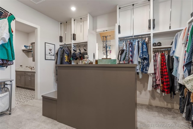 walk in closet featuring light colored carpet and a sink