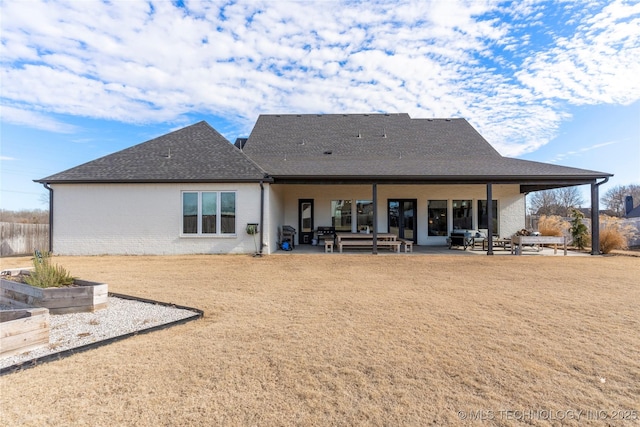 back of property featuring a patio area, a shingled roof, and brick siding