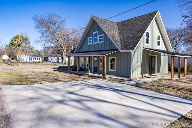 view of front facade with a shingled roof, a porch, and board and batten siding