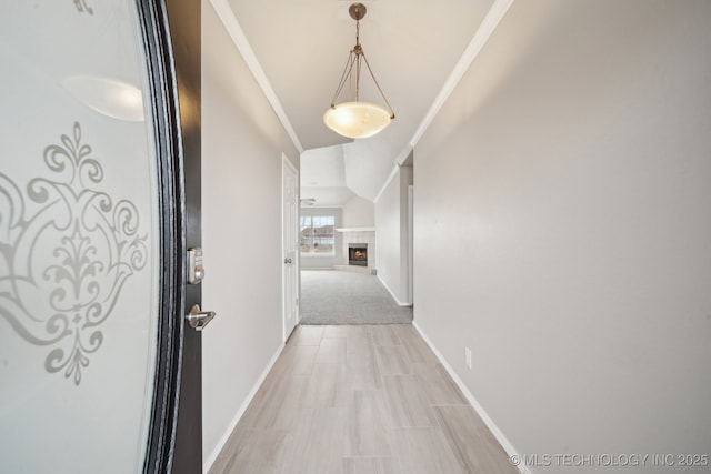 hall with ornamental molding and baseboards