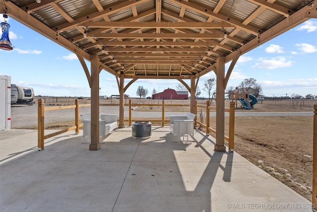 view of patio / terrace with a playground, fence, a gazebo, and a rural view