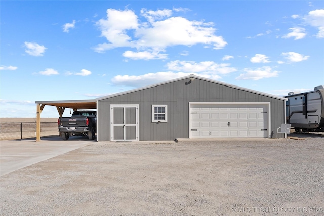 garage featuring a detached garage and fence