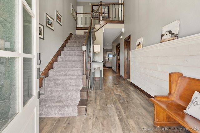 entryway featuring a high ceiling, stairway, and wood finished floors