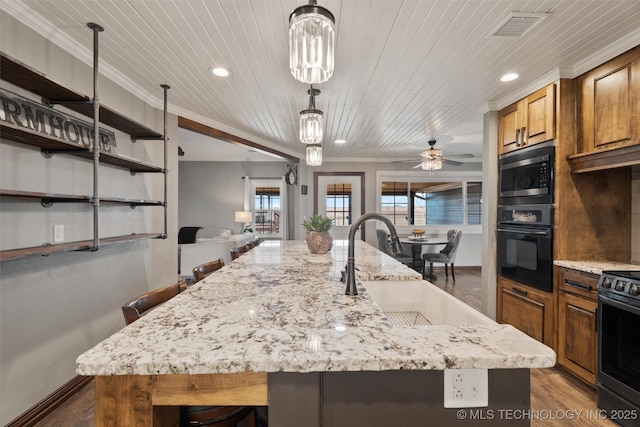 kitchen with electric range, visible vents, stainless steel microwave, a sink, and black oven
