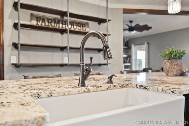 room details with open shelves, light stone counters, and a sink
