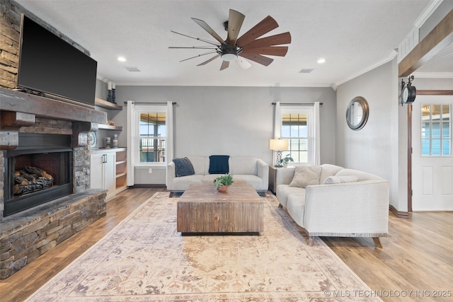 living room featuring plenty of natural light, crown molding, and wood finished floors