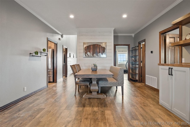 dining area with visible vents, crown molding, baseboards, and wood finished floors