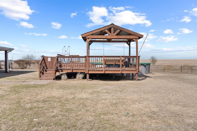 exterior space featuring fence, a deck, a lawn, and a gazebo