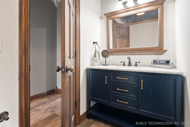 bathroom with wood finished floors, vanity, and baseboards