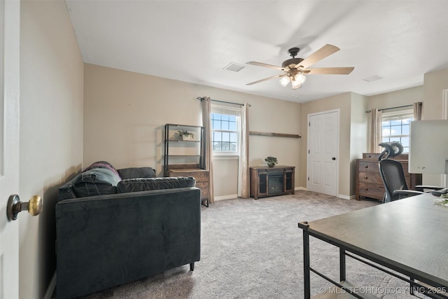 office space with baseboards, a healthy amount of sunlight, visible vents, and light colored carpet