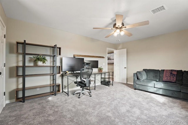 carpeted office space featuring baseboards, visible vents, and a ceiling fan