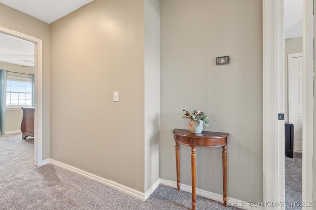 hallway featuring carpet floors and baseboards