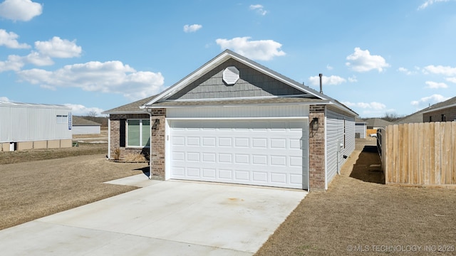 view of front of home featuring a garage, fence, concrete driveway, and brick siding