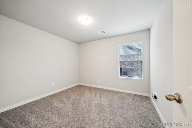 carpeted spare room with baseboards and visible vents