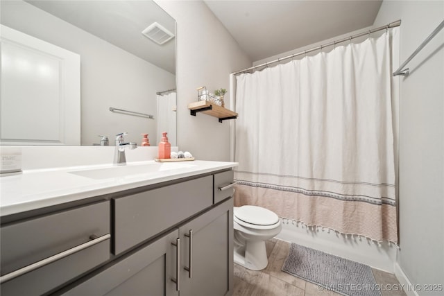 full bathroom with toilet, visible vents, wood finished floors, and vanity