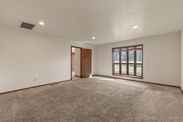 carpeted empty room with baseboards, visible vents, and recessed lighting