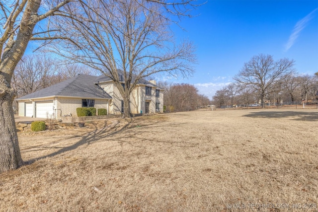 view of yard with an attached garage and driveway