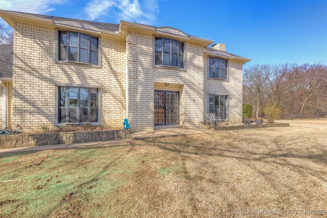 view of front of home with brick siding and a front lawn