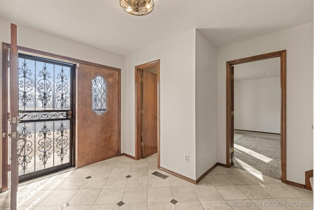 entrance foyer featuring visible vents, baseboards, and light tile patterned flooring