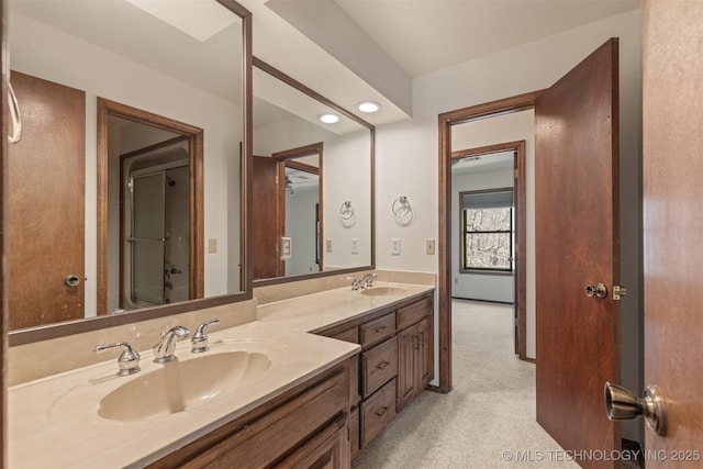 full bath with double vanity, a sink, and recessed lighting