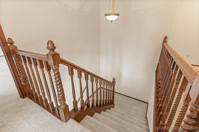 staircase featuring carpet