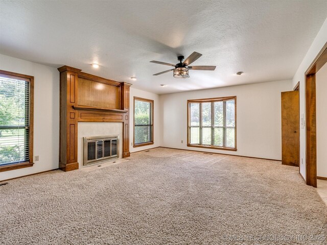 8934 S 41st W Ave, Tulsa, OK 74132 - unfurnished living room with a ceiling fan, a fireplace, light carpet, and a textured ceiling