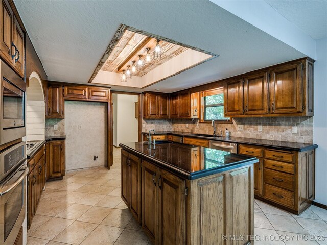 8934 S 41st W Ave, Tulsa, OK 74132 - kitchen with dark countertops, stainless steel appliances, backsplash, a textured ceiling, and light tile patterned floors