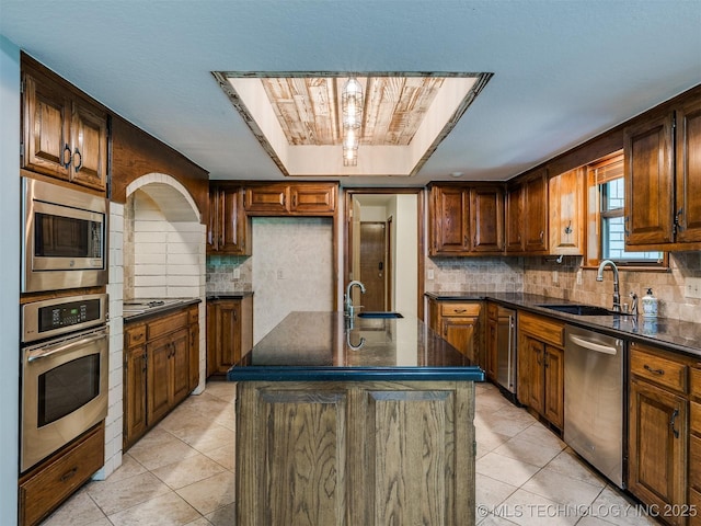 8934 S 41st W Ave, Tulsa, OK 74132 - kitchen featuring stainless steel appliances, backsplash, light tile patterned floors, and a tray ceiling