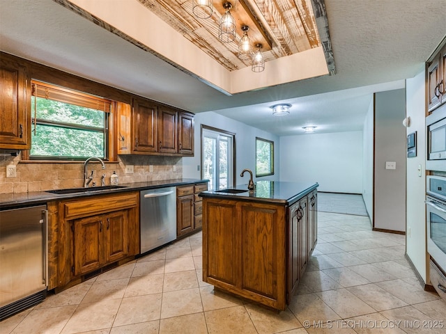 8934 S 41st W Ave, Tulsa, OK 74132 - kitchen with stainless steel appliances, dark countertops, decorative backsplash, and light tile patterned floors
