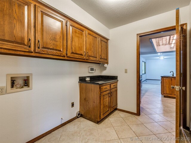 8934 S 41st W Ave, Tulsa, OK 74132 - washroom with cabinet space, hookup for a washing machine, light tile patterned floors, and a skylight