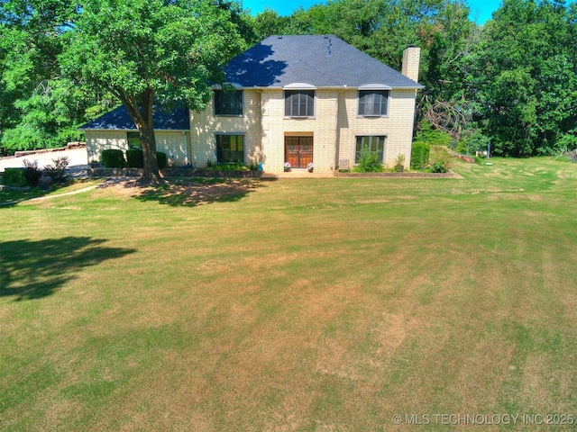 8934 S 41st W Ave, Tulsa, OK 74132 - view of front of house with a chimney, a front yard, and brick siding