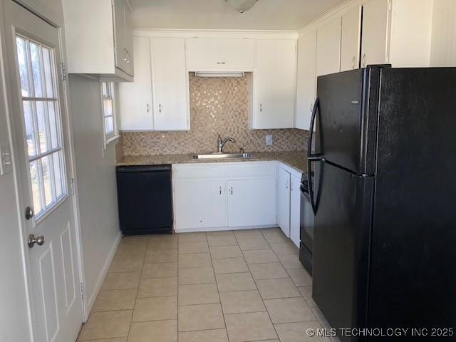 kitchen featuring backsplash, white cabinets, a sink, light tile patterned flooring, and black appliances