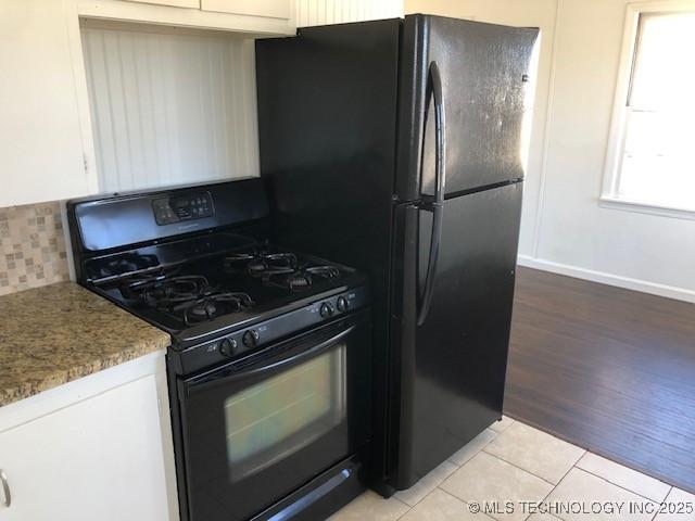 kitchen featuring black appliances, white cabinets, backsplash, and light tile patterned flooring