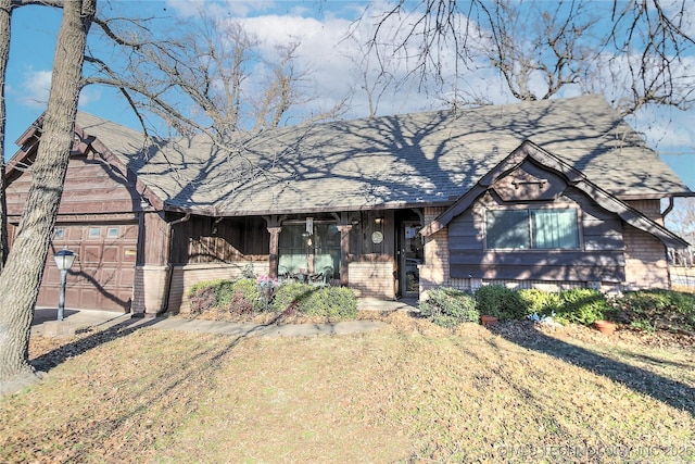 view of front facade featuring a shingled roof, a front lawn, and an attached garage