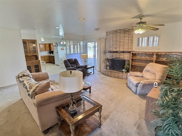 living room featuring a brick fireplace, ceiling fan, and light colored carpet