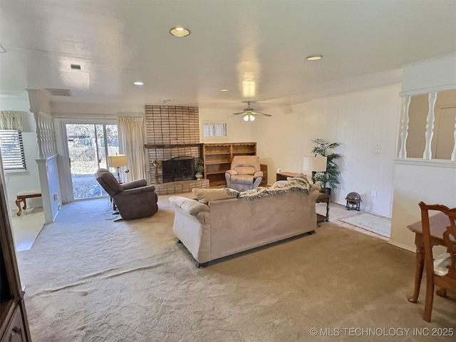 carpeted living area featuring a brick fireplace, ceiling fan, visible vents, and recessed lighting